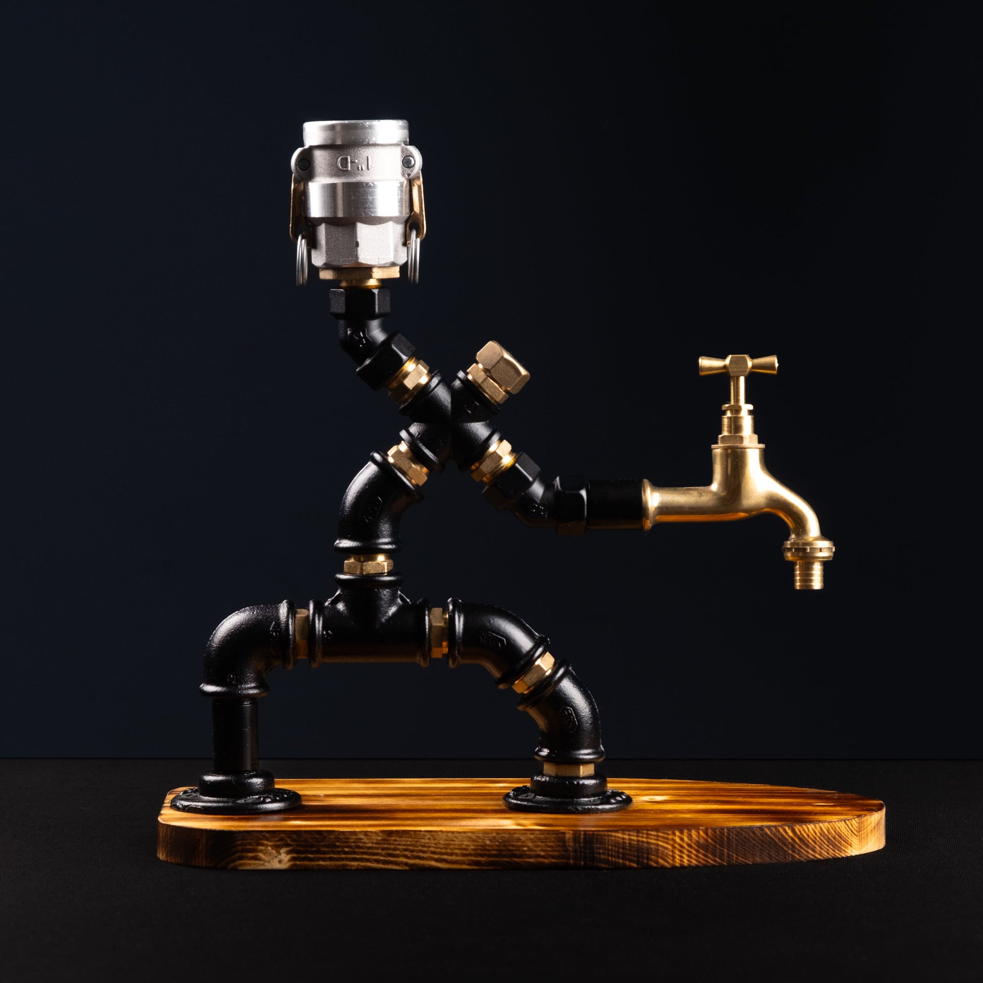 A rustic style liquor dispenser with a metallic brass body and a wooden base, featuring a single button on top for dispensing.